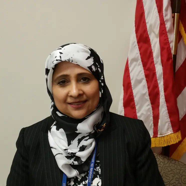A headshot of Engineer Farah Gilani next to the American flag. 